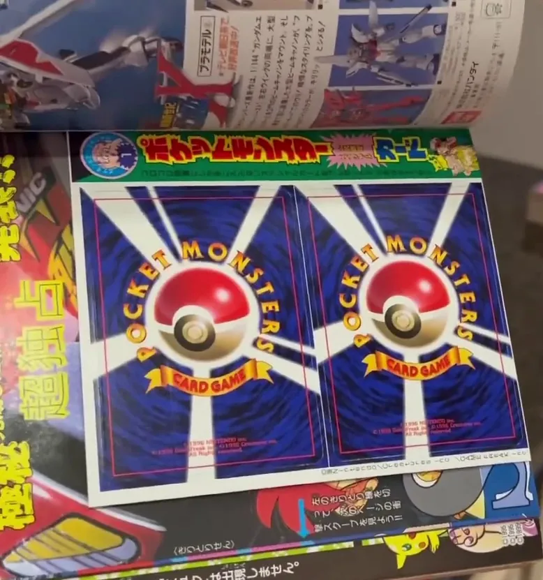 An unpeeled two-card insert inside CoroCoro issue 223, showing the card backs and the printed cut lines